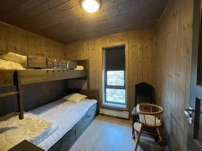 a bedroom with a bunk bed and a chair at Hjertebo by Norgesbooking - cabin at Spåtind in Nord Torpa