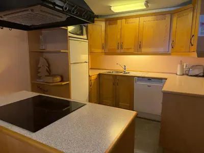 a kitchen with wooden cabinets and a white refrigerator at Comfort, Sauna & Great Location! in Beitostøl