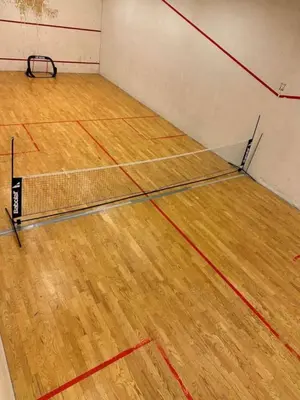 a tennis court with a net on a wooden floor at Ny leilighet med eget treningsstudio under ski-vm i Trondheim in Fannrem