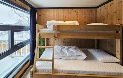 two bunk beds in a wooden room with a window at 3 Bedroom Awesome Apartment In Rjukan in Rjukan
