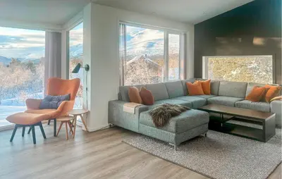 a living room with a couch and a table and chairs at Awesome Home In Oppdal With Sauna in Oppdal