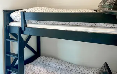 two bunk beds in a room with a chair at Awesome Home In Oppdal With Sauna in Oppdal