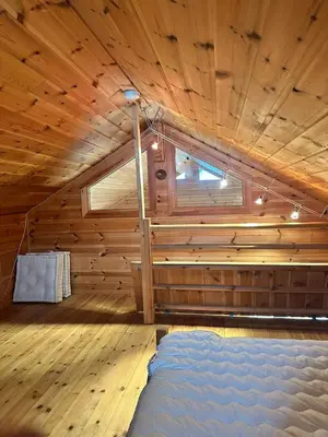 a room with a bed in a wooden cabin at Convenient ski in-out on Norefjell in the alpine village in Surteberg