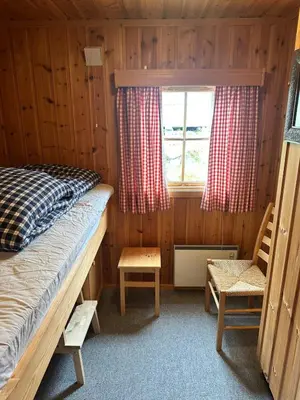 a bedroom with a bed and a window and a chair at Convenient ski in-out on Norefjell in the alpine village in Surteberg