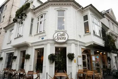 a white building with a cafe open sign on it at City center retreat with king bed in Bergen