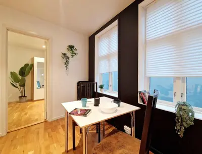 a dining room with a table and two windows at City center retreat with king bed in Bergen