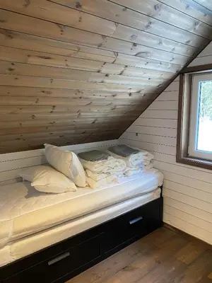 a bed in a room with a wooden ceiling at FrysiaHouse in Lillehammer