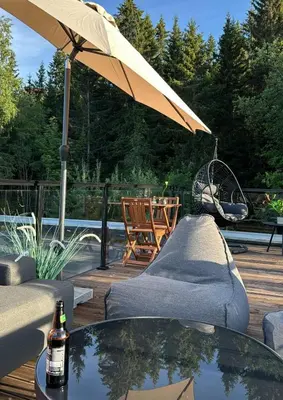 a patio with a table and an umbrella on a deck at Moderne hjem med høy standard og privat takterasse in Trondheim