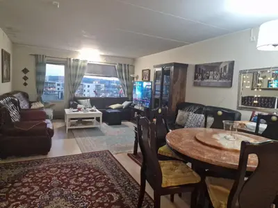a living room with a table and a couch at Flatåsensenteret in Kystad