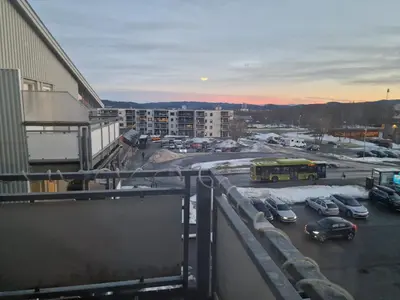 a view of a parking lot with cars and a bus at Flatåsensenteret in Kystad