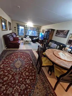 a living room with a table and a couch at Flatåsensenteret in Kystad