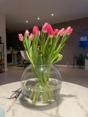 a glass vase with pink flowers in it on a table at Feriebolig sentralt og nærme Ski VM in Tiller