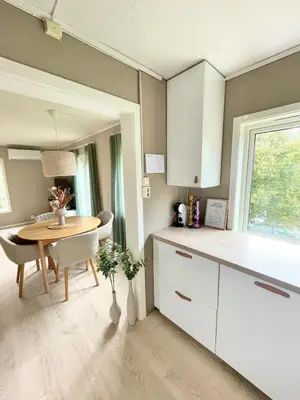 a kitchen with a table and a dining room at Cozy and spacious apartment in Trondheim