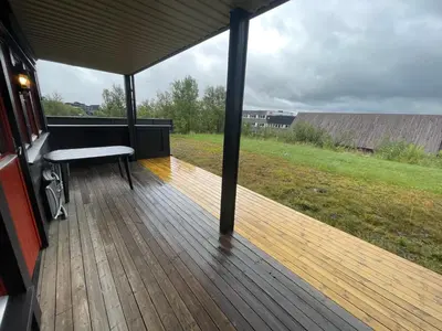 a porch with a bench on a wooden deck at Spacious Retreat With Sauna And Parking in Beitostøl