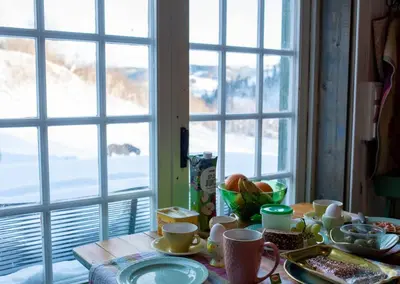 a table with cups and dishes on it with a window at Cozy Cabin Retreat in Scenic Valley, E6 south of Trondheim in Storen