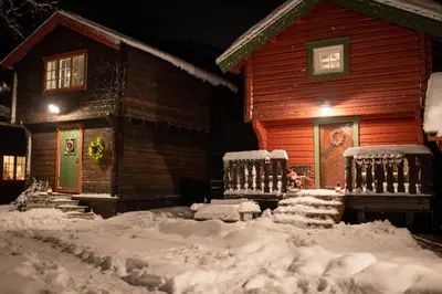 a house covered in snow in front of a house at Cozy Cabin Retreat in Scenic Valley, E6 south of Trondheim in Storen