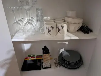 a shelf with cups and other items on it at Koselig kjellerleilighet, gratis parkering! in Trondheim