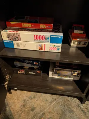a shelf filled with video game boxes on it at Koselig kjellerleilighet, gratis parkering! in Trondheim