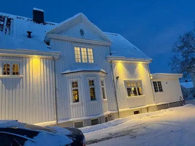 a house covered in snow with lights on it at Exclusive villa in Trondheim in Trondheim