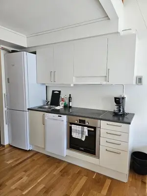 a kitchen with white cabinets and a laptop on the counter at Mountain view 2 in Håra