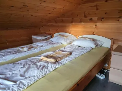 a large bed in a room with wooden walls at Hardangerfjord panorama 1 in Kvam