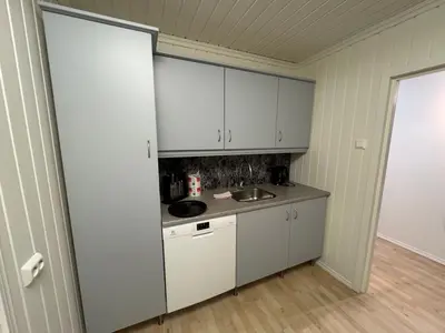 a kitchen with white cabinets and a sink at Apartment with a beautiful view in the center of Ålesund in Ålesund