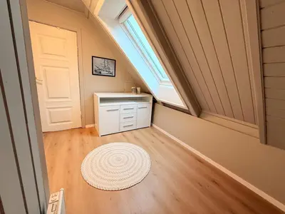 a attic room with a sink and a window and a door at Historic Charm in Bergens Heart in Bergen