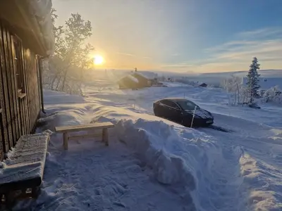 a car parked in the snow next to a house at Newly renovated, centrally located family cabin with mountain view in Beitostøl