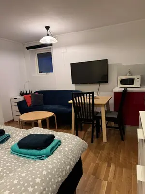 a living room with a couch and a table and a tv at Nice apartment in quiet neighborhood in Trondheim