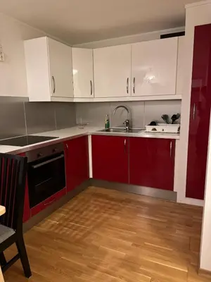 a kitchen with red and white cabinets and a sink at Nice apartment in quiet neighborhood in Trondheim
