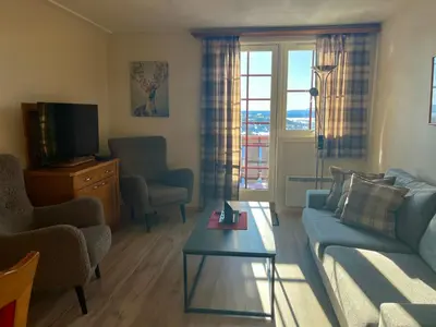 a living room with a couch and a tv at Leilighet midt i sentrum in Beitostøl