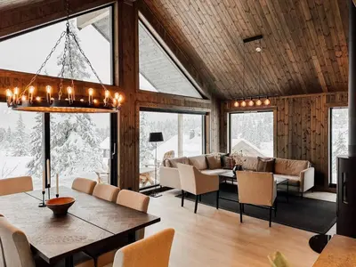 a dining room and living room with a table and chairs at Modern Mountain Cabin - Sauna - 5 Bedrooms - Sleeps for 10 in Torpo
