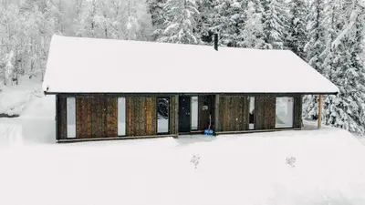 a cabin covered in snow with trees in the background at Modern Mountain Cabin - Sauna - 5 Bedrooms - Sleeps for 10 in Torpo