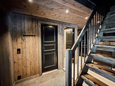 a wooden hallway with a door and stairs at Modern Mountain Cabin - Sauna - 5 Bedrooms - Sleeps for 10 in Torpo