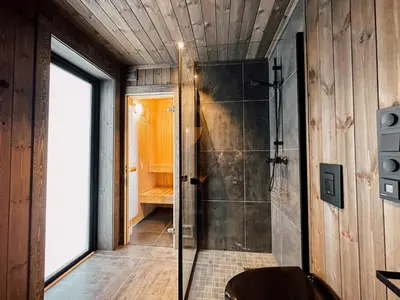 a bathroom with a shower with a glass door at Modern Mountain Cabin - Sauna - 5 Bedrooms - Sleeps for 10 in Torpo