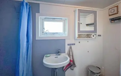 a bathroom with a sink and a mirror and a window at Gorgeous Home In Svingvoll in Svingvoll