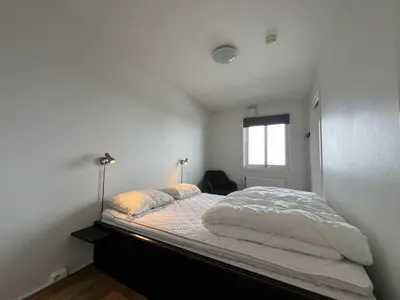 a white bedroom with a large bed with a window at Bright, Homey Apartment In Beitostølen Center in Beitostøl