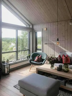 a living room with a couch and a chair and windows at Enjoy The Calm Setting Of This Cozy Family Cabin in Etnedal