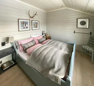 a bedroom with a bed with pink pillows at Traditional Cabin In Gålå With Stunning Nature in Gålå