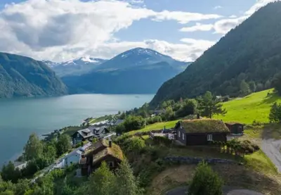 a village on a hill next to a body of water at Panoramic Cabin With Fjord Views In Valldal in Valldal