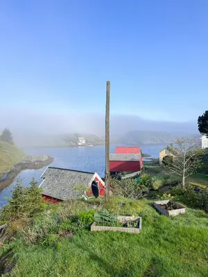a house on a hill next to a body of water at Historic Villa By The Sea In Solund in Hardbakke