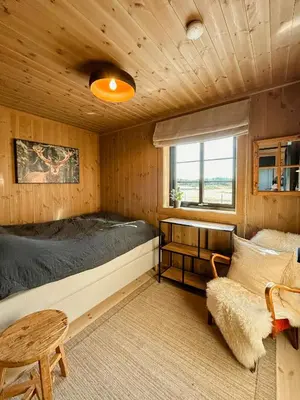 a bedroom with a bed and a table and a chair at Cozy Modern Mountain Cabin At Kvamsfjellet in Kvam