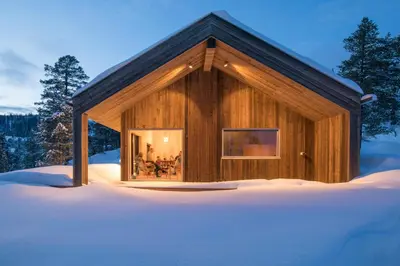a log cabin in the snow in the woods at Cabin By Selbusjøen With Ski And Trail Access in Selbu