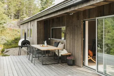 a patio with a table and chairs on a deck at Cabin By Selbusjøen With Ski And Trail Access in Selbu