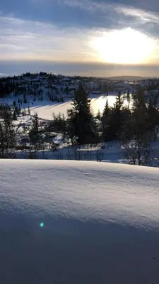 a field covered in snow with the sun in the background at Mountain Cabin With Views And Close To Ski Trails in Aurdal