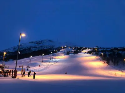 a group of people skiing down a snow covered slope at night at Designer Cabin With Panoramic Views In Hovden in Bykle