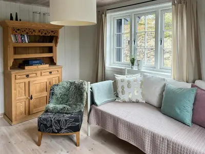 a living room with a couch and a chair at Designer Cabin With Panoramic Views In Hovden in Bykle