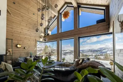 a living room with large windows and a couch at Architect-Designed Cabin Near Hardangerfjord in Garnes