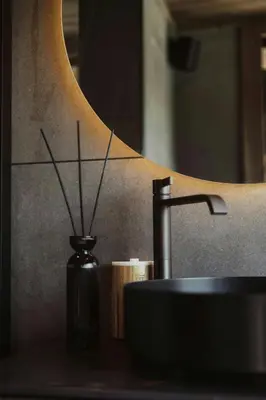 a bathroom sink and a vase with sticks in it at Architect-Designed Cabin Near Hardangerfjord in Garnes