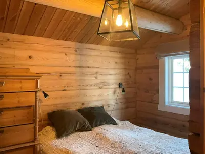 a bedroom with a bed in a wooden cabin at Idyllic Log Cabin At Nordseter in Lillehammer
